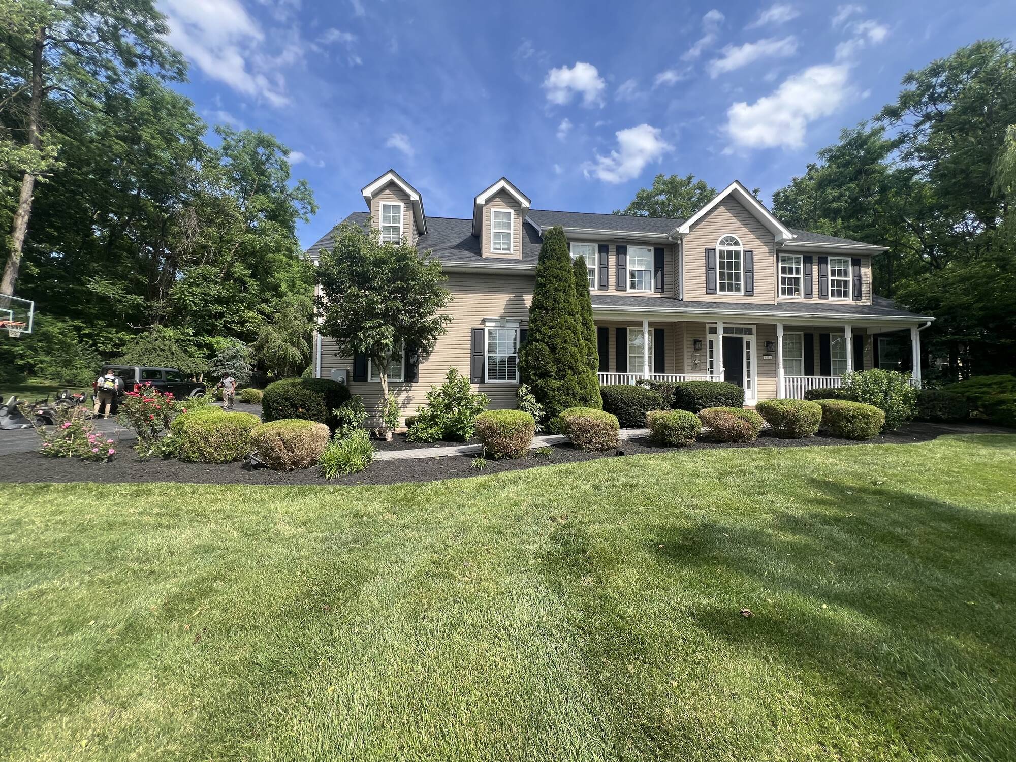 Two-story home with freshly trimmed shrubs and mulched flower beds